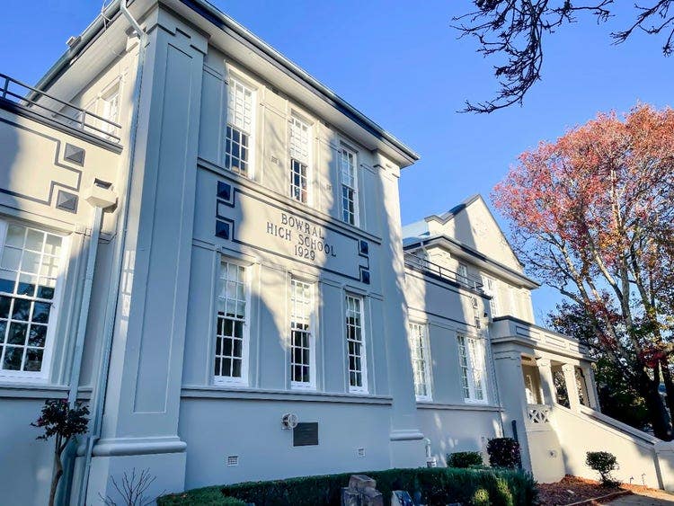 Bowral High School building, established 1929, with large white windows and autumn trees.